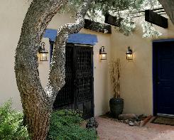 Entrance to Sandhill Crane Bed and Breakfast is shaded by a Pinon tree and Wisteria